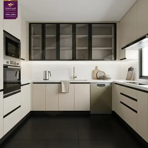 مطبخ بأرضية سوداء وخزائن كريمية وخزائن علوية بإطارات سوداء وزجاج مضاء وأجهزة مدمجة.